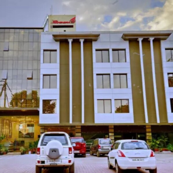 A modern building with a glass facade and a sign reading "Hotel". - Hotel Mahendra (Raipur)