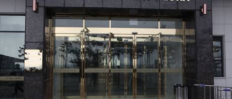 The entrance to Hotel Wooyheon Flora with glass doors and a clear view of the interior.