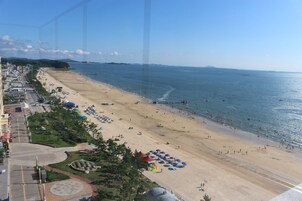 A beach with umbrellas and people.