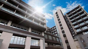 Un edificio de varios pisos con balcones y ventanas amplias, probablemente un hotel o complejo de apartamentos.