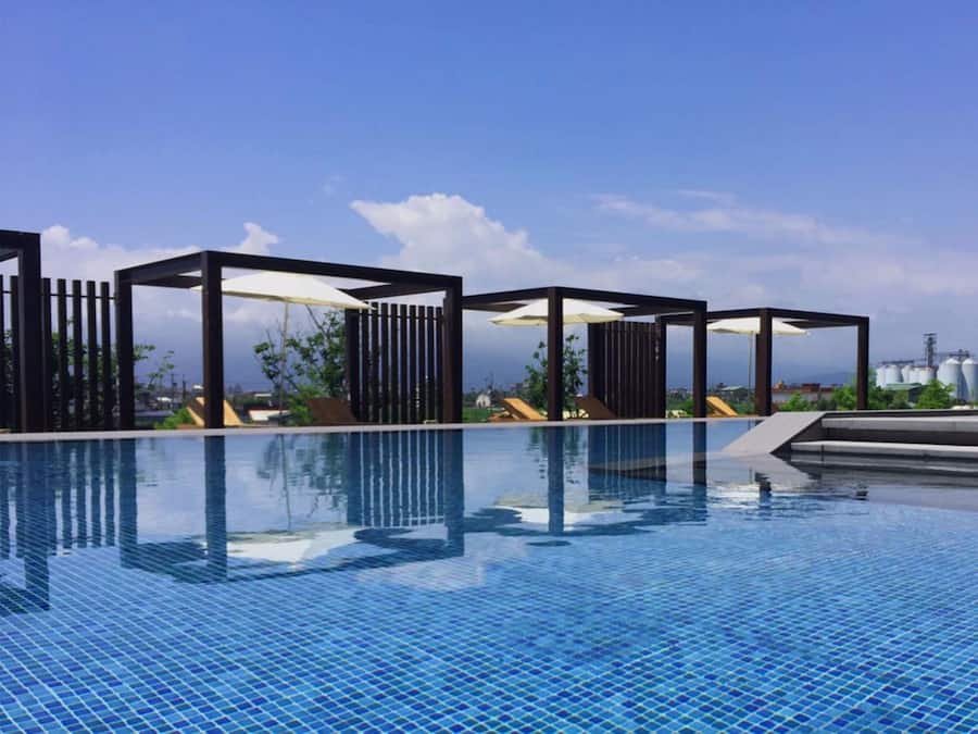 Una piscina al aire libre de temporada, sombrillas