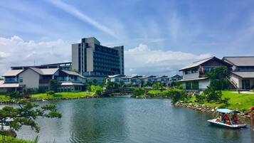 Un hotel frente al lago con edificios modernos, un puente y un bote en el agua.