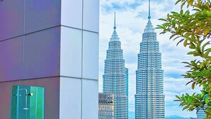 A modern building with a glass facade and a view of the Petronas Towers. - Saba Suites at Platinum KLCC Kuala Lumpur (Kuala Lumpur)