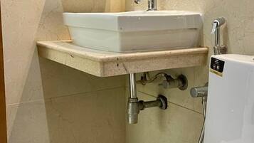 A bathroom with a white sink, a toilet, and a mirror.