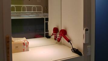 A hotel room with a bunk bed, a mirror, and a set of drawers labeled 103-1 to 103-4.