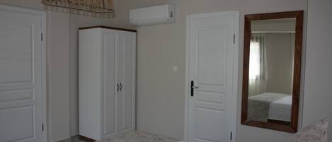 A bedroom with a bed, wardrobe, and mirror.