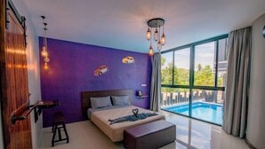Un dormitorio moderno con una cama grande, un taburete pequeño, un banco y vistas a una piscina.