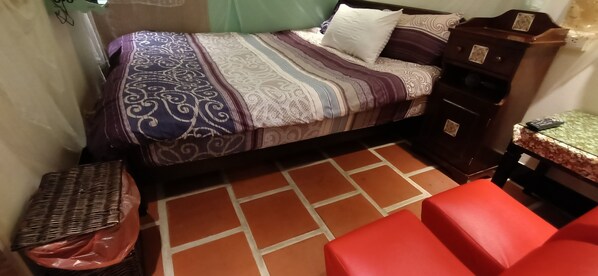 A small, compact room with a bed, a small table, and a chair. - Biiann B&B (Jinning)