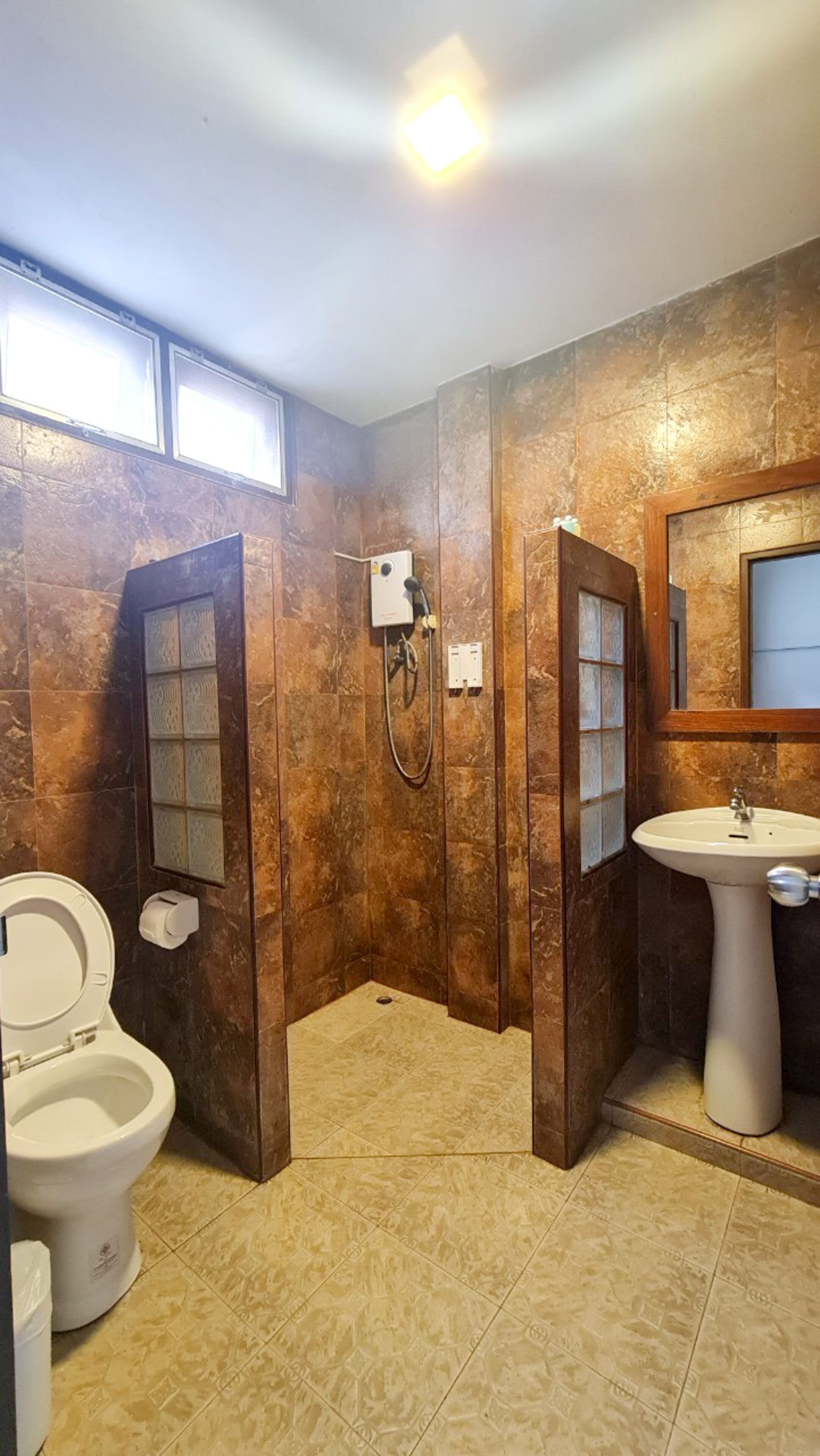 Un bagno con il water, una doccia e un lavandino.