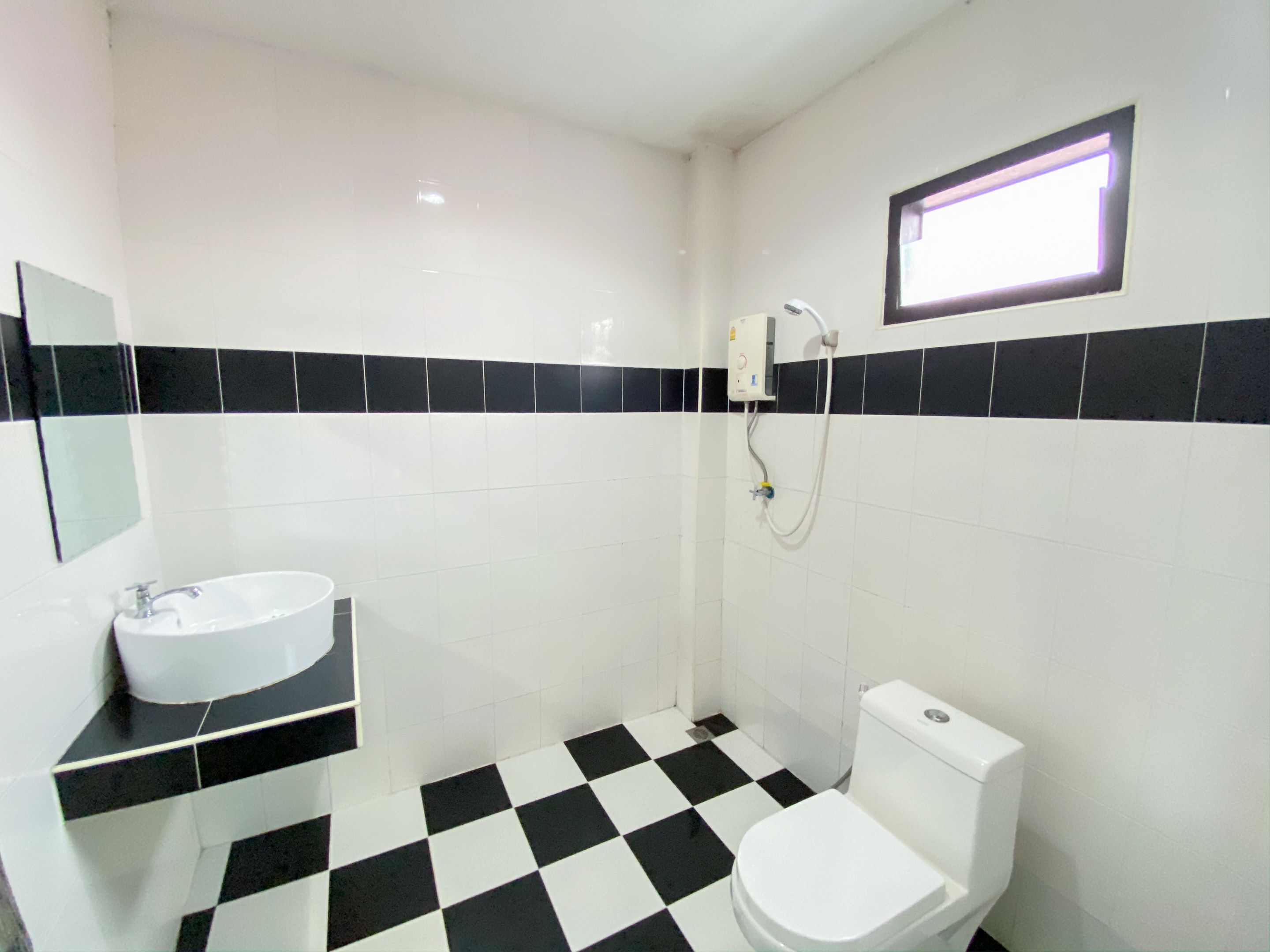 A bathroom with a black and white checkered floor, a white sink, and a toilet.