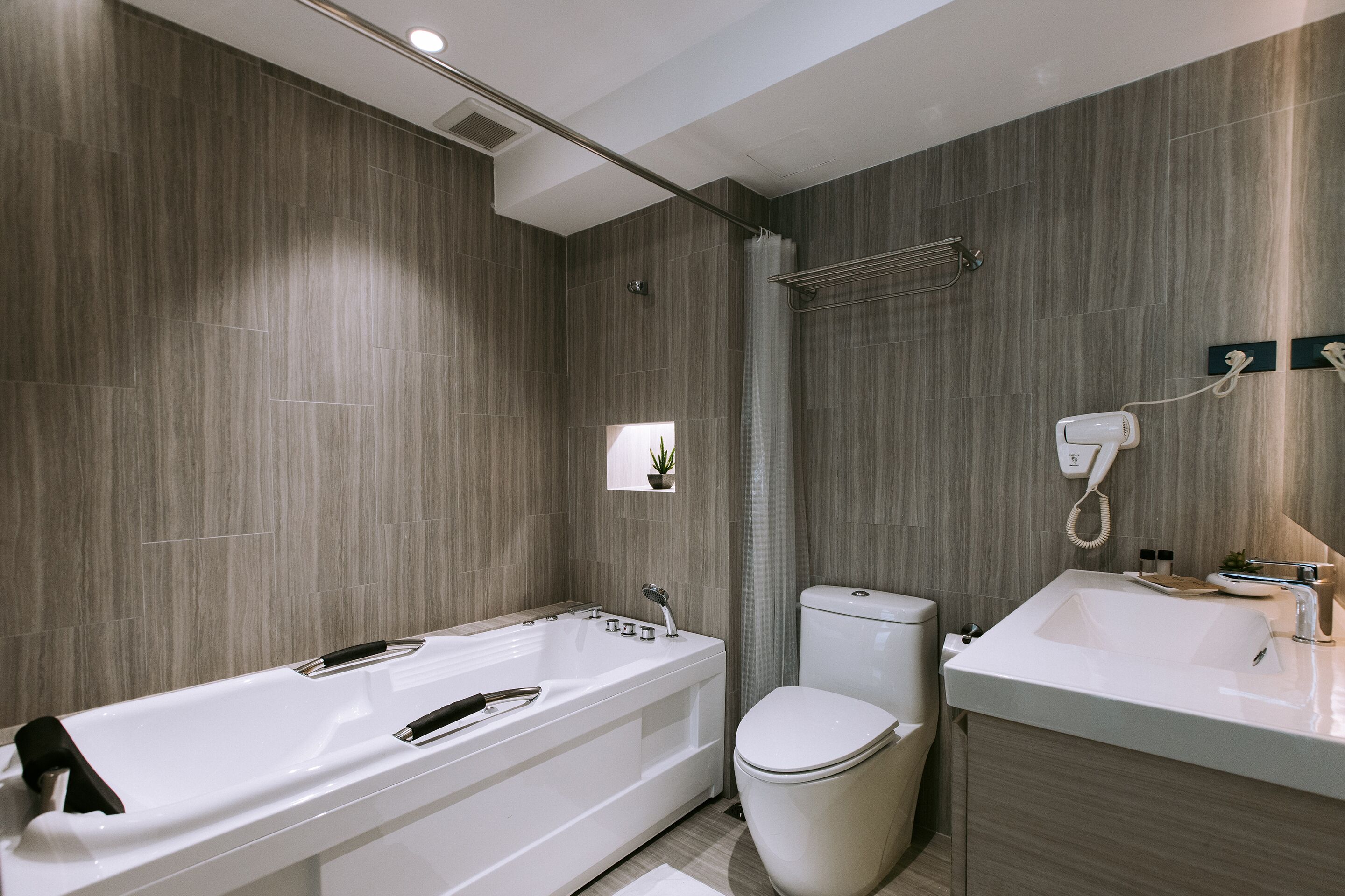 A modern bathroom with a bathtub, toilet, and sink.