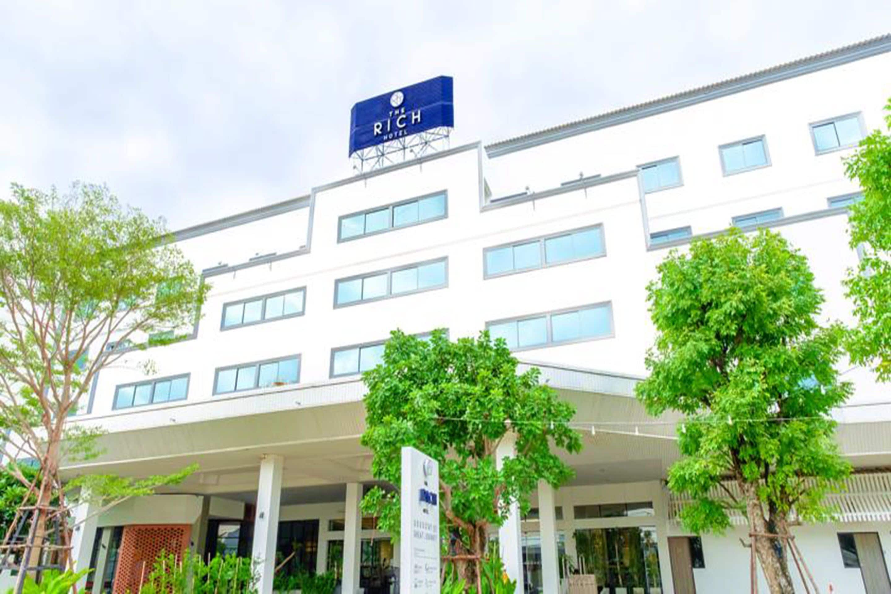 Un hôtel moderne avec une enseigne bien visible portant l’inscription « The Rich Hotel ».