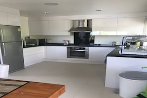 A modern kitchen with white cabinets, stainless steel appliances, and a central island.