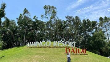 A sign for FAMINGO RESORT in DAILA with a person standing in front.