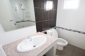 A bathroom with a white sink, a toilet, and a shower. - Alynda Place (Nakhon Ratchasima)