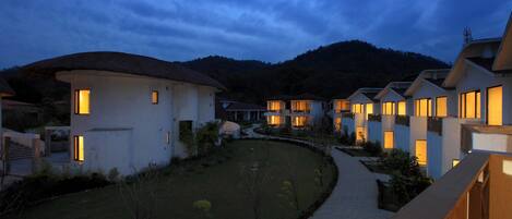 A resort with multiple buildings, a well-maintained lawn, and a pathway leading to the entrance.