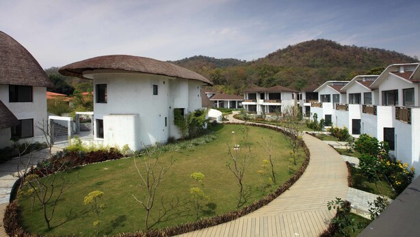 A residential area with modern houses, a curved pathway, and a grassy lawn.