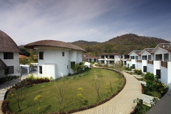 A residential area with modern houses, a curved pathway, and a grassy lawn.