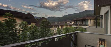 A balcony with a view of traditional buildings and a mountain in the background.
