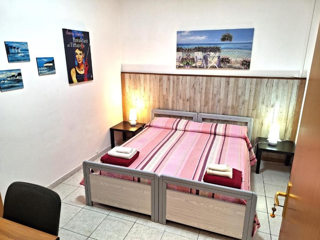 Una camera da letto con un letto, due comodini, una sedia e opere d'arte alle pareti.
