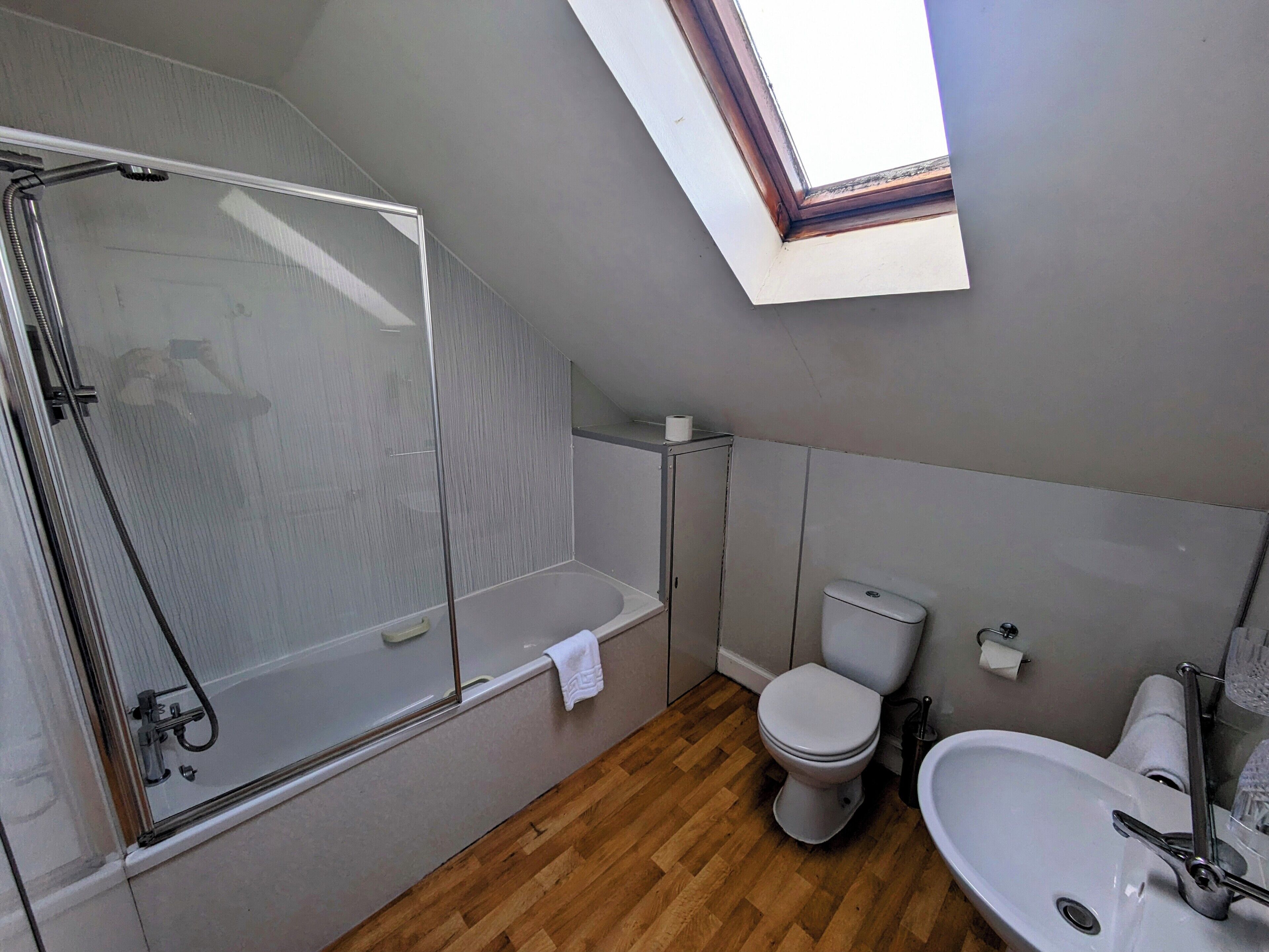 A bathroom with a shower, toilet, and sink.