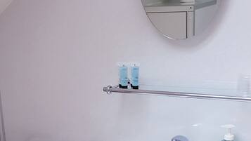 A bathroom with a white sink, a mirror, and a towel rack.