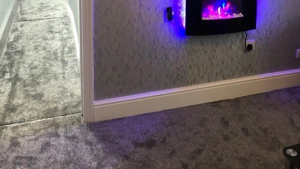 Quarto com lareira, televisão na parede e corredor que dá para outro espaço.