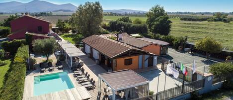 Una villa con piscina, mobiliario de exterior y vistas al campo.