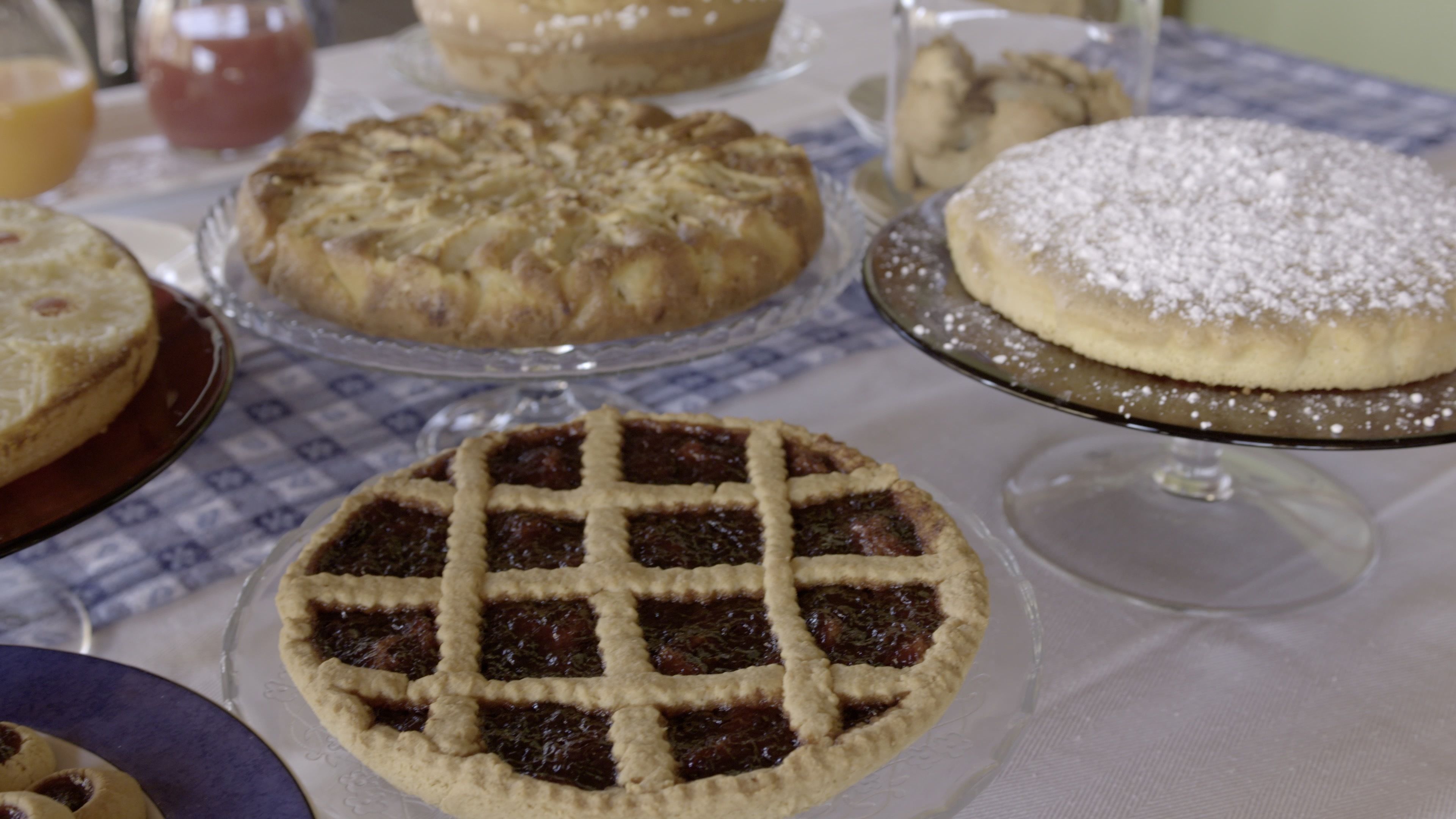 Variedad de postres sobre una mesa, entre ellos tartas y pasteles.