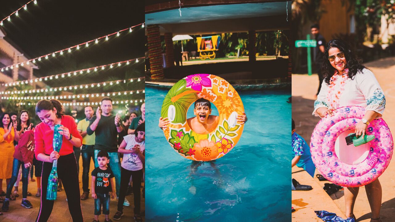 A pool area with string lights, a person holding a colorful inflatable ring, and another person holding a similar ring.