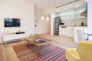 A modern kitchen with a built-in microwave, stainless steel refrigerator, and a sink.