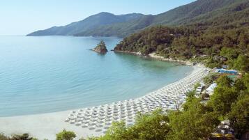 Trên bãi biển, ghế dài tắm nắng, dù trên bãi biển, khăn tắm biển