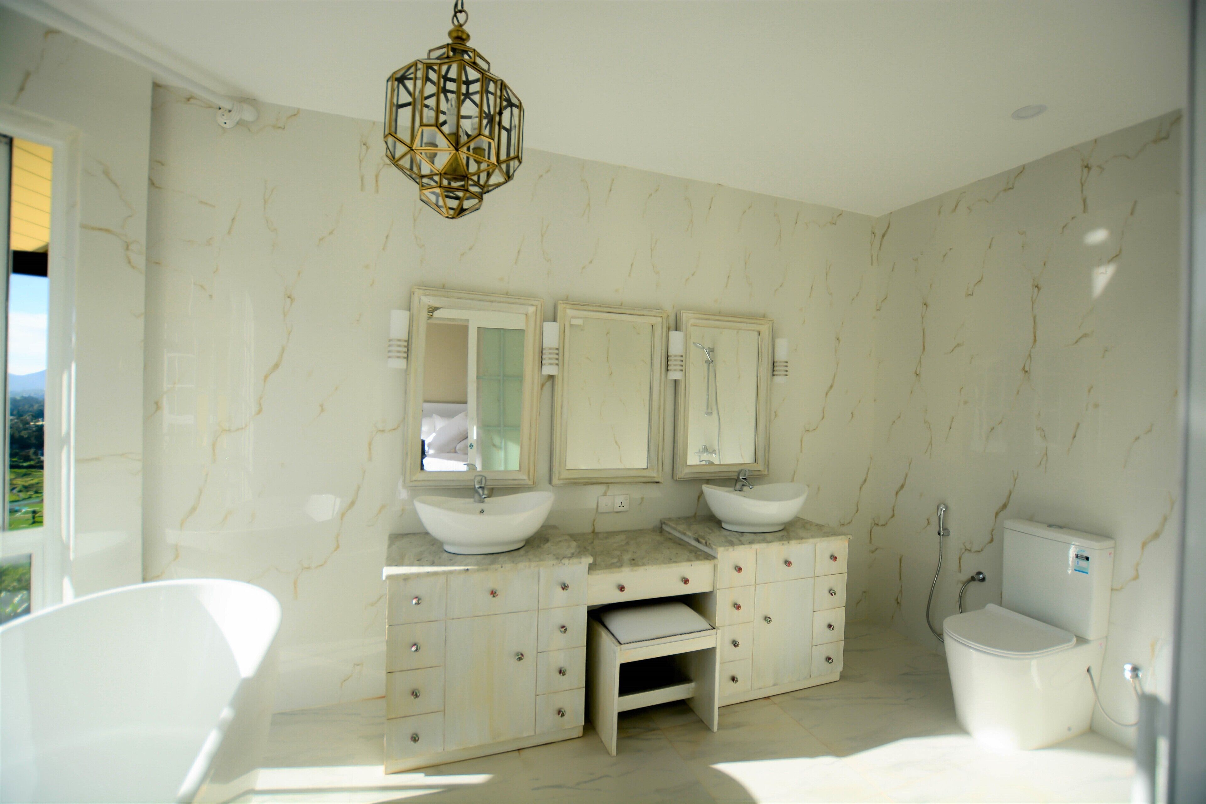 A bathroom with two sinks, a toilet, and a vanity with drawers.