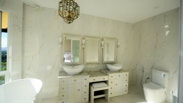 A bathroom with two sinks, a toilet, and a vanity with drawers.