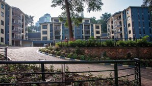 A courtyard with a paved walkway, surrounded by multi-story buildings with balconies. - Mayflower Serviced Apartments (Kampala)