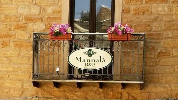 A building with a stone facade and a balcony with flower boxes. - B&B Mannala' (Agrigento)