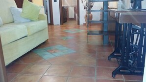 A living room with a sofa, a coffee table, and a tiled floor. - B&B Mannala' (Agrigento)