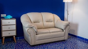 A beige sofa in a room with a blue tiled floor and a white lamp. - Aquae Romanae Bed and Breakfast Sorrento (Sorrento)