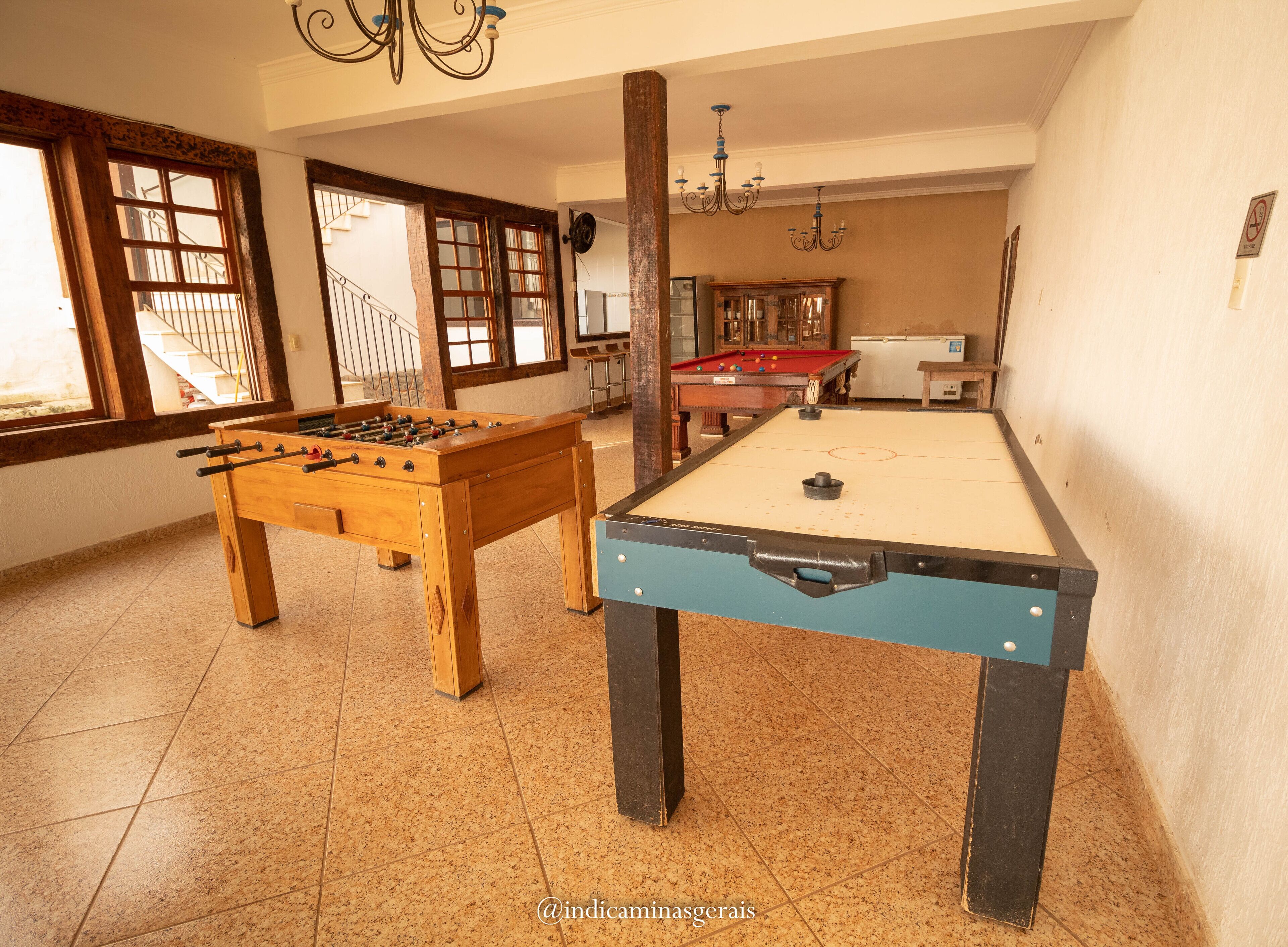 Una habitación con mesa de fútbol, mesa de billar y mesa de aficiones.