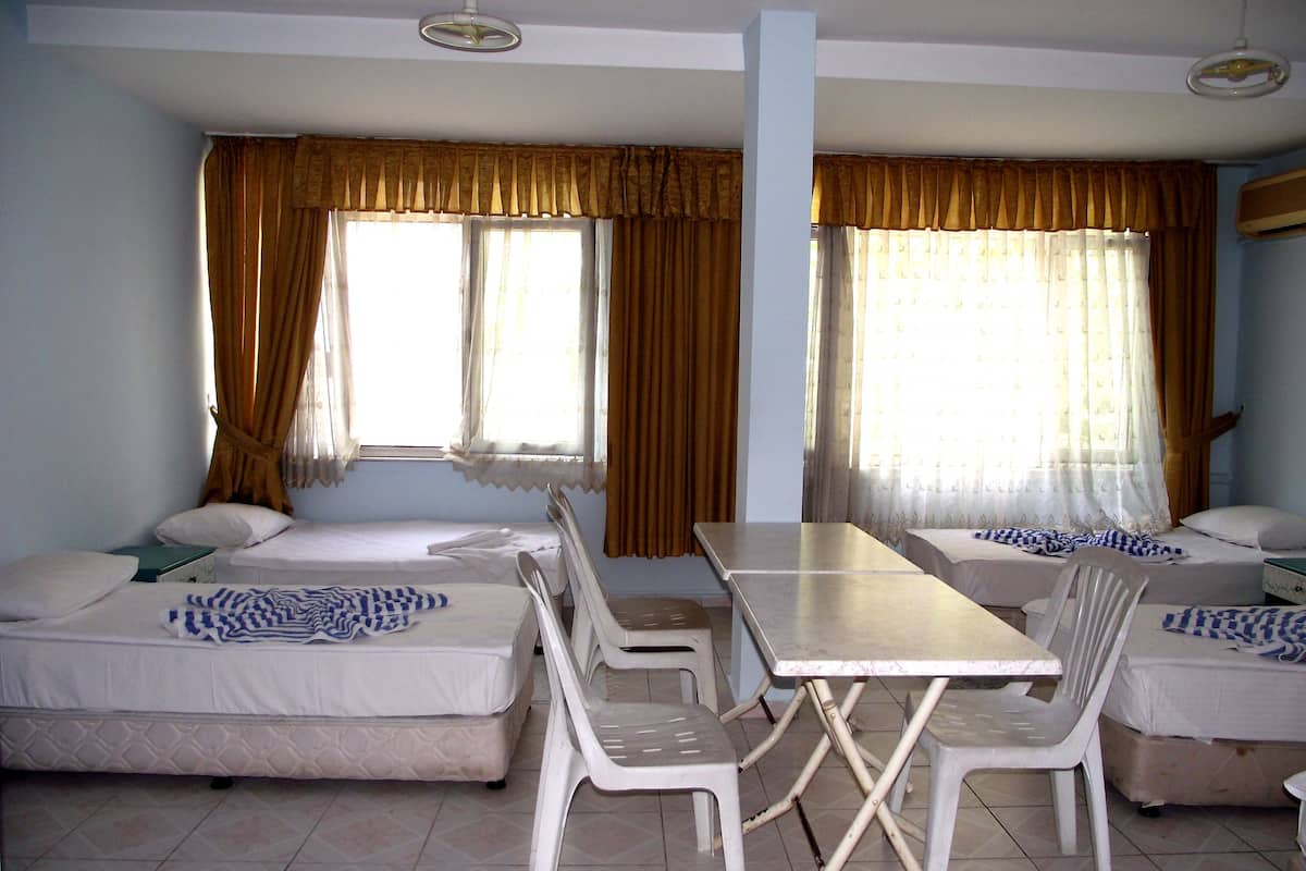 A room with two beds, a table, and chairs.
