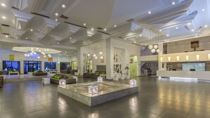 Un hall d’entrée spacieux doté d’un espace salon central, de plusieurs niveaux et d’un éclairage moderne.