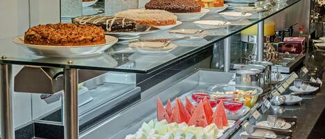 A buffet with various food items and a glass display case.
