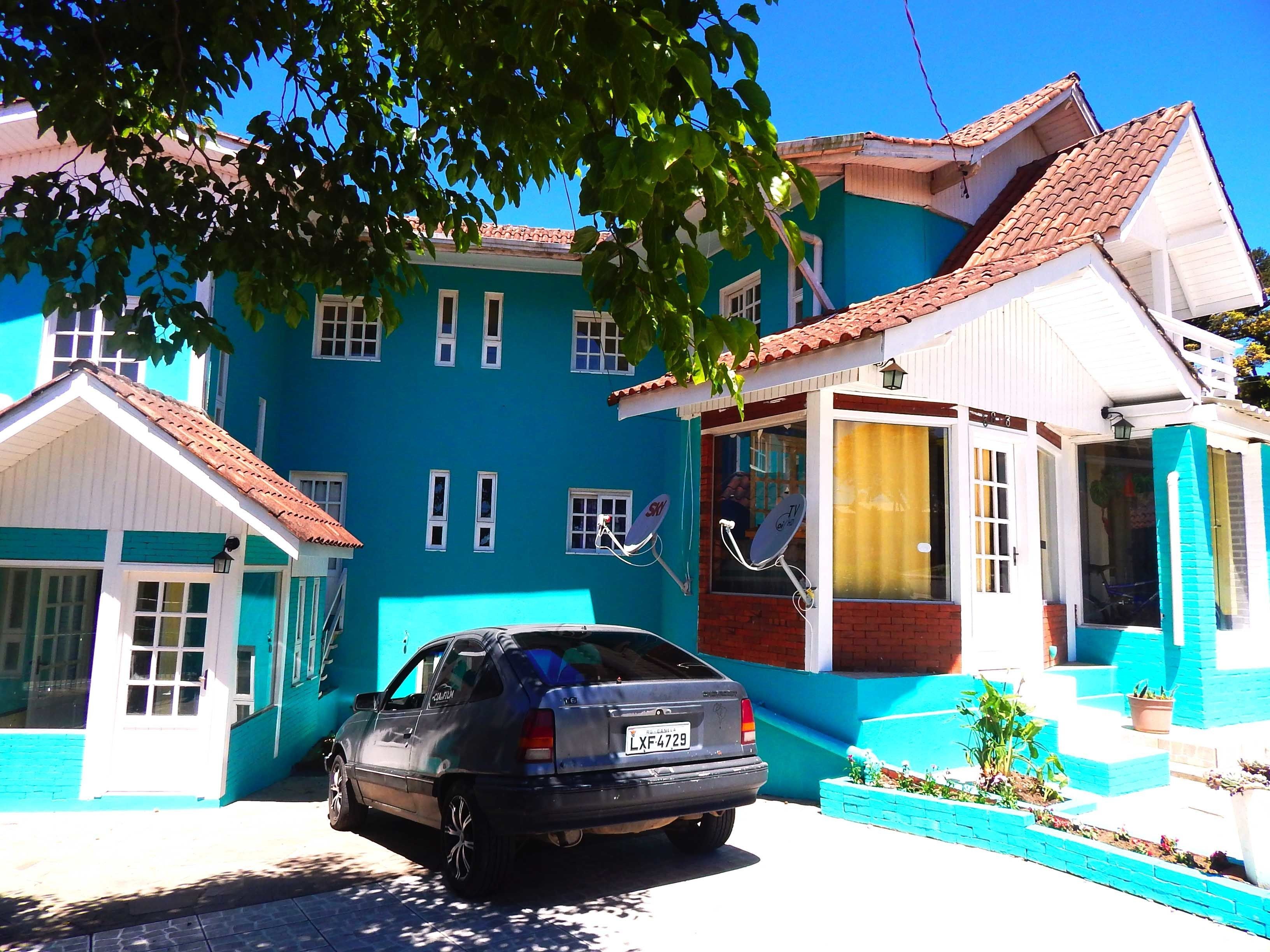 A blue building with a car parked in front.