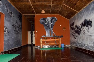 Un pasillo decorado con murales de cebras, un elefante y búfalos en las paredes.