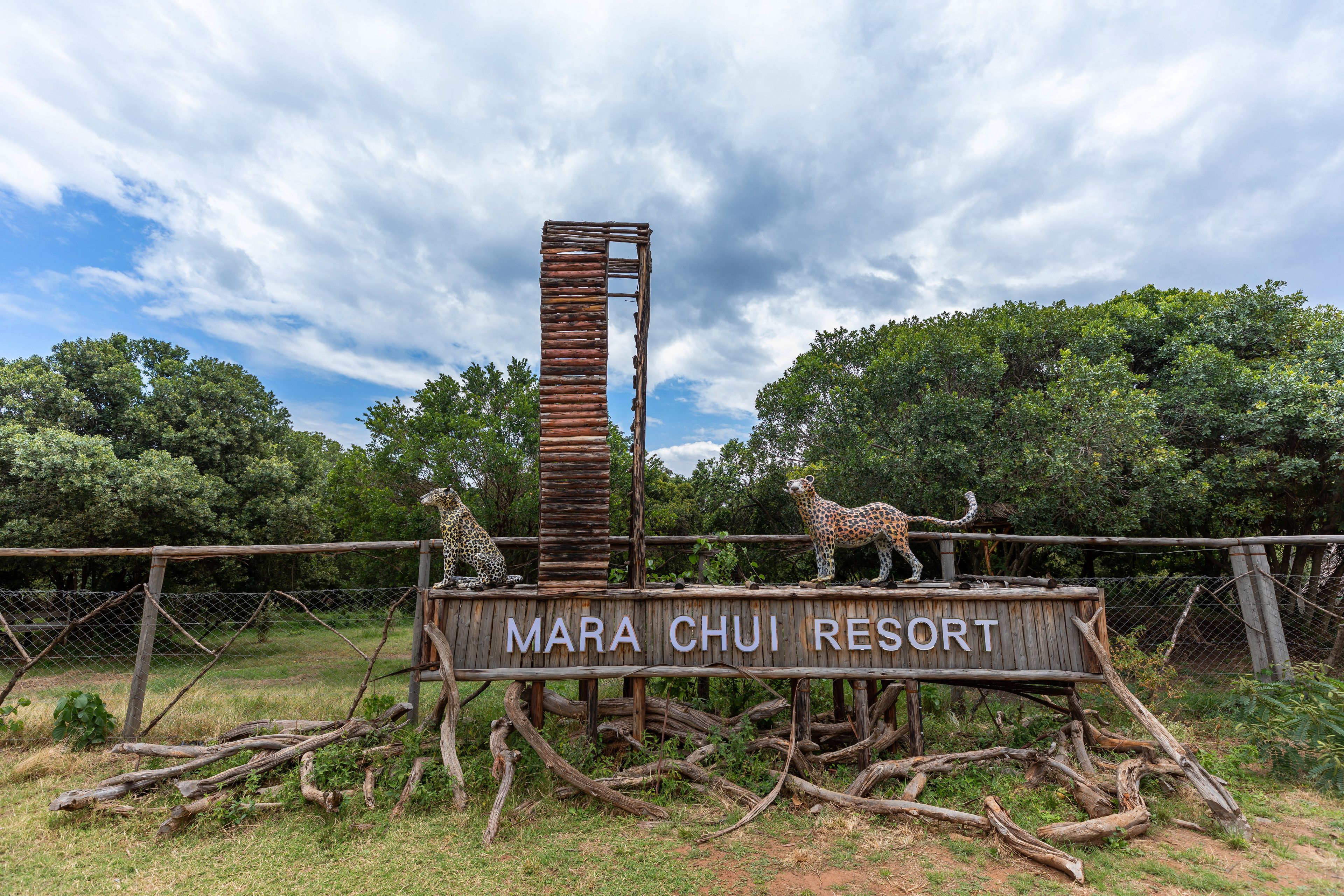 Un letrero de madera con jirafas y el texto "MARA CHUI RESORT".