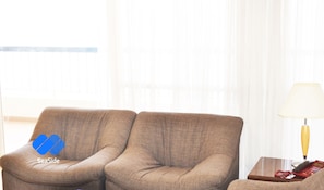 Suite urbana, vista parcial al mar | Sala de estar | Televisión de pantalla plana