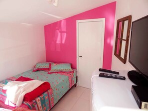 A small bedroom with a bed, a white dresser, a TV, and a door. - Lake Apartament Triplo (Canela)