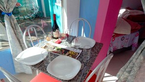 Een gedekte eettafel met borden, glazen, bestek, een fles wijn en een menukaart.
