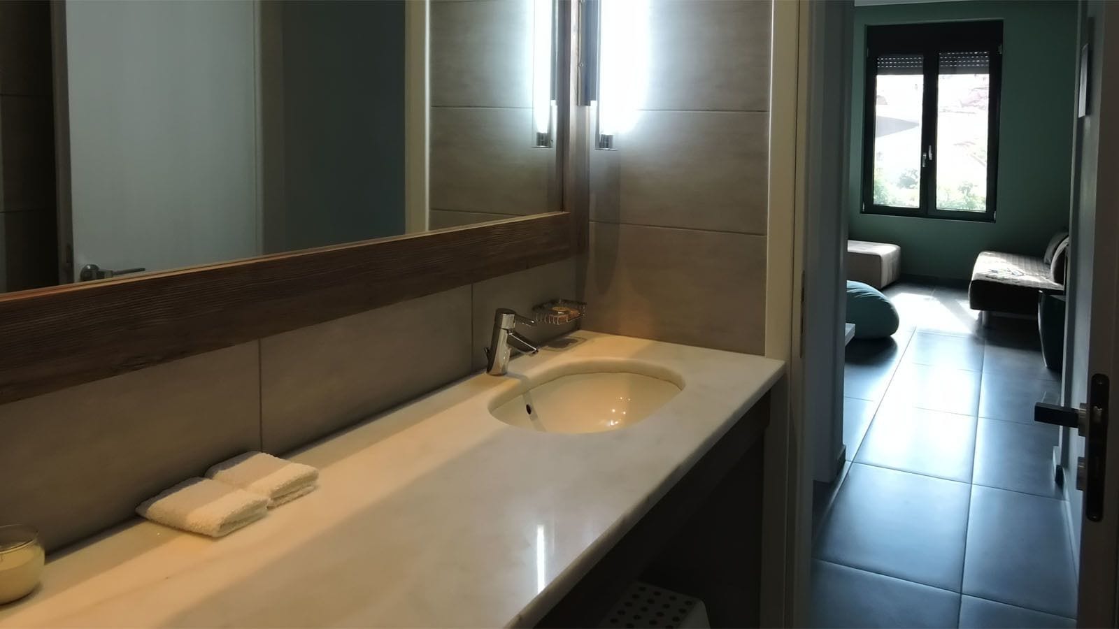 Uma casa de banho moderna com um espelho grande, uma sanita branca e uma casa de banho.