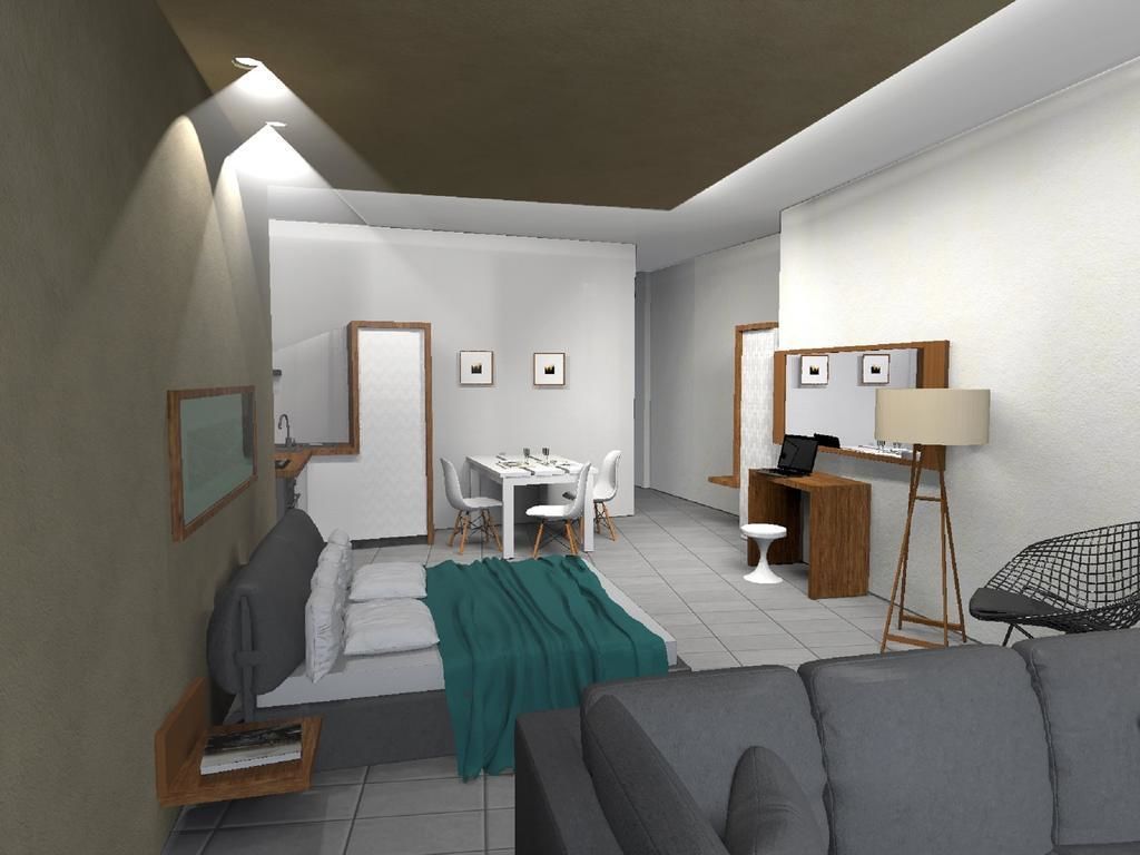 A modern, well-lit room with a bed, a desk, a chair, and a sofa.